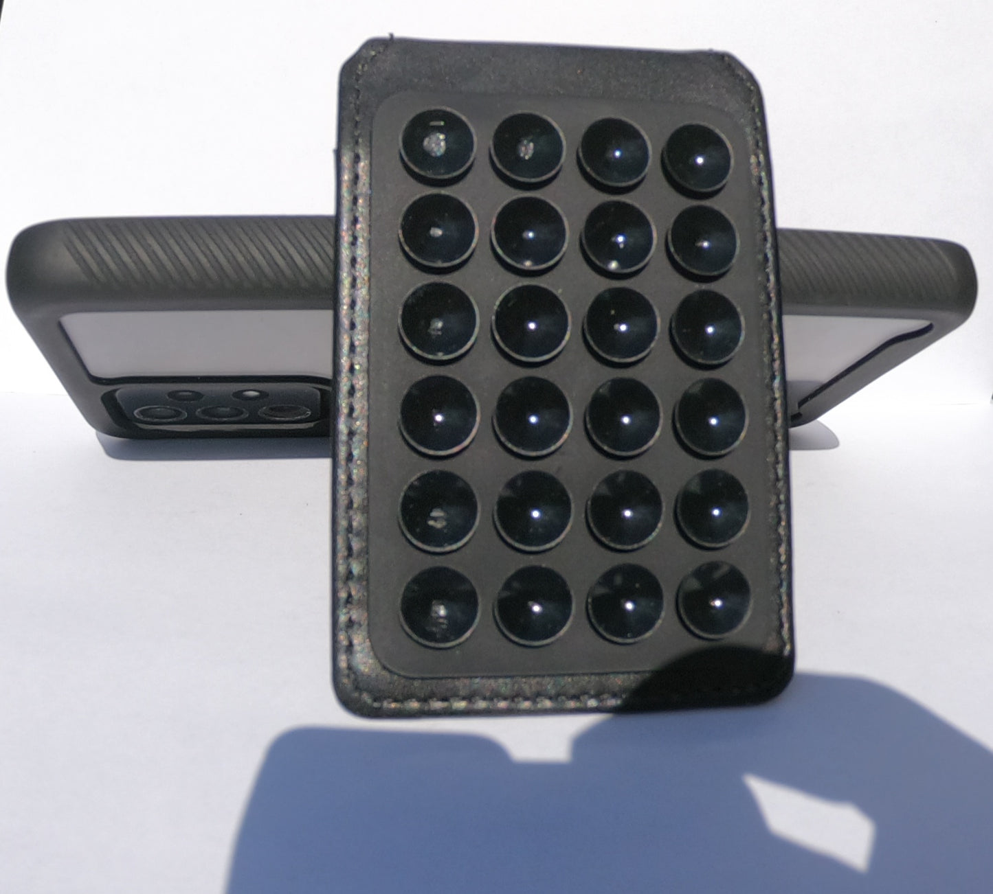 It is a Reusable!! Card,money,and stash pocket/cell phone wallet that uses 24 suction cups instead of glue or adhesive with and integrated finger ring for easy use and control of your smartphone or tablet and it can be used as a stand.